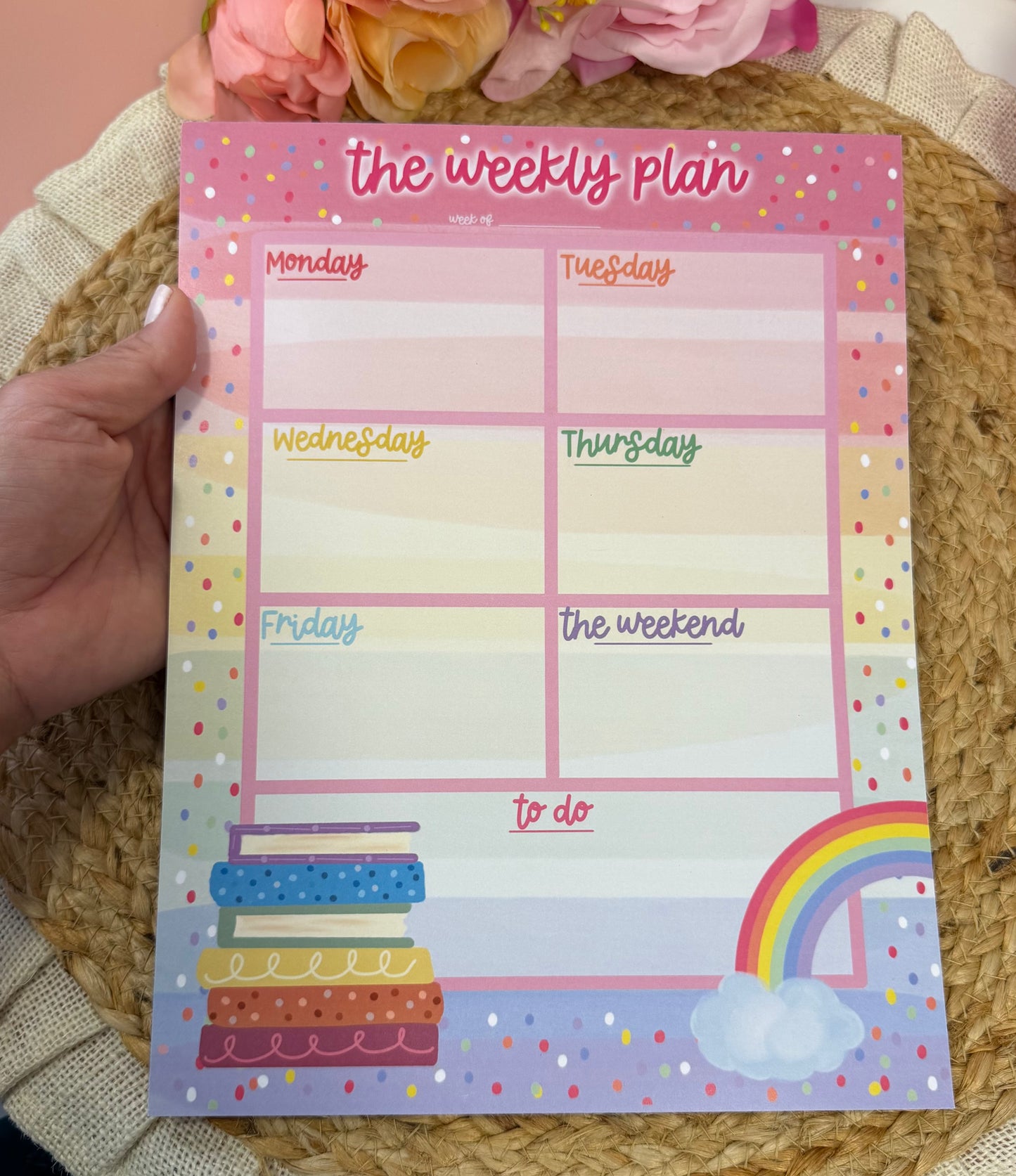 Rainbow Books Weekly Planner held in hand to show its size and design.