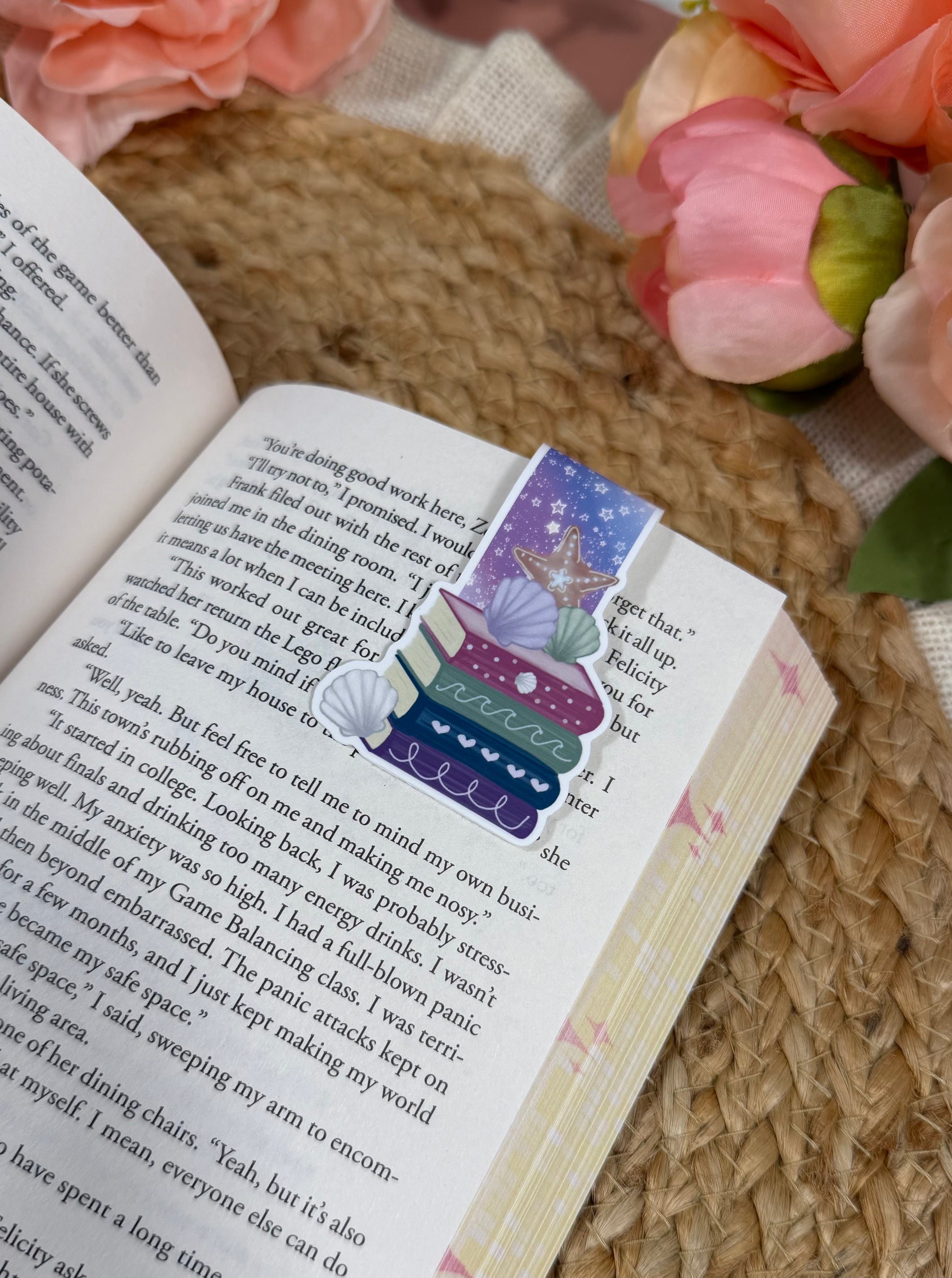 Close-up of the Beach Books magnetic bookmark clipped to a book page, highlighting the artwork and design details.