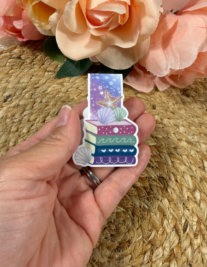 Beach Books magnetic bookmark held in hand to show its size and beach-inspired design.