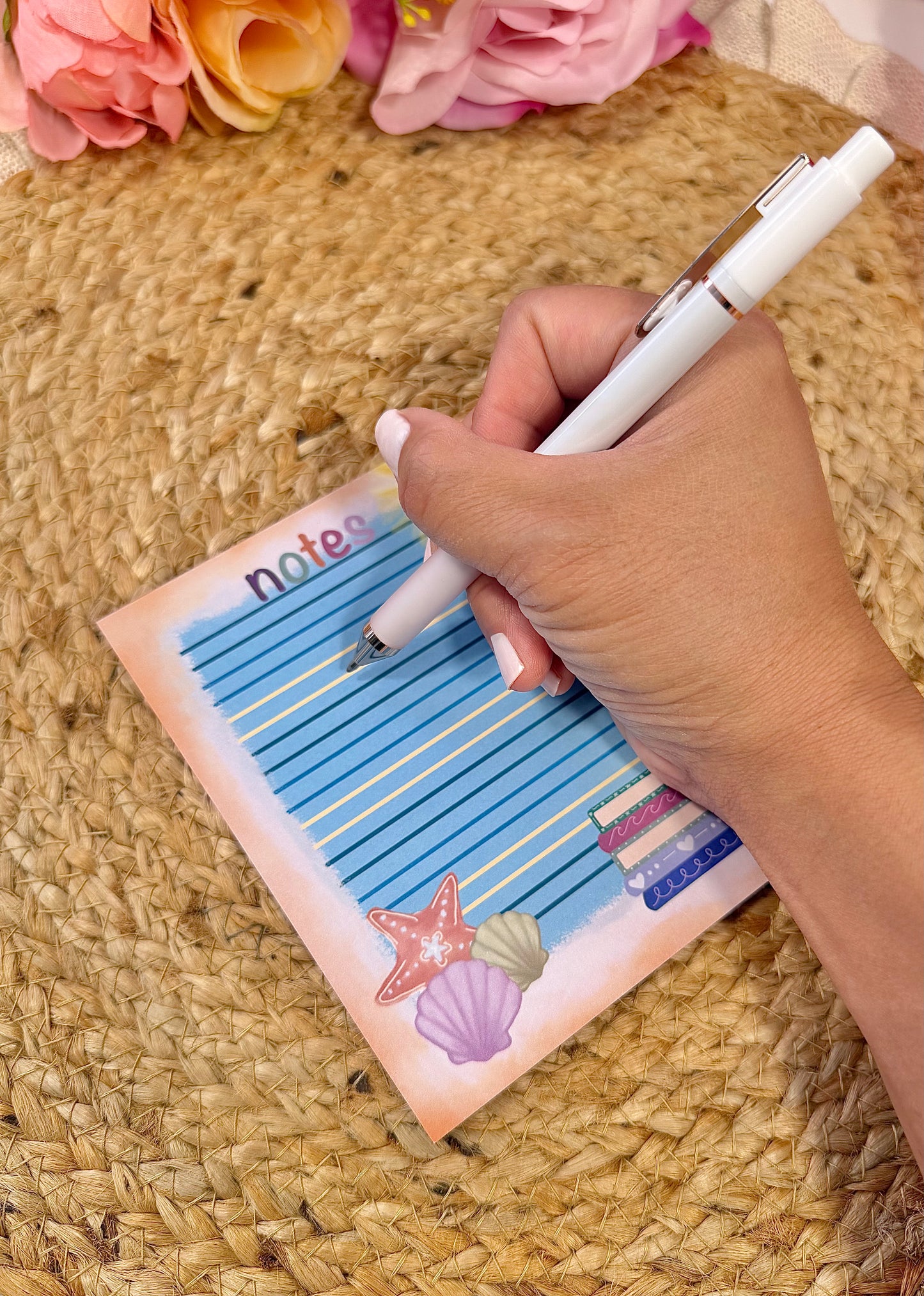 Beach Books Notepad held in hand with a pen to show its size and writing space.