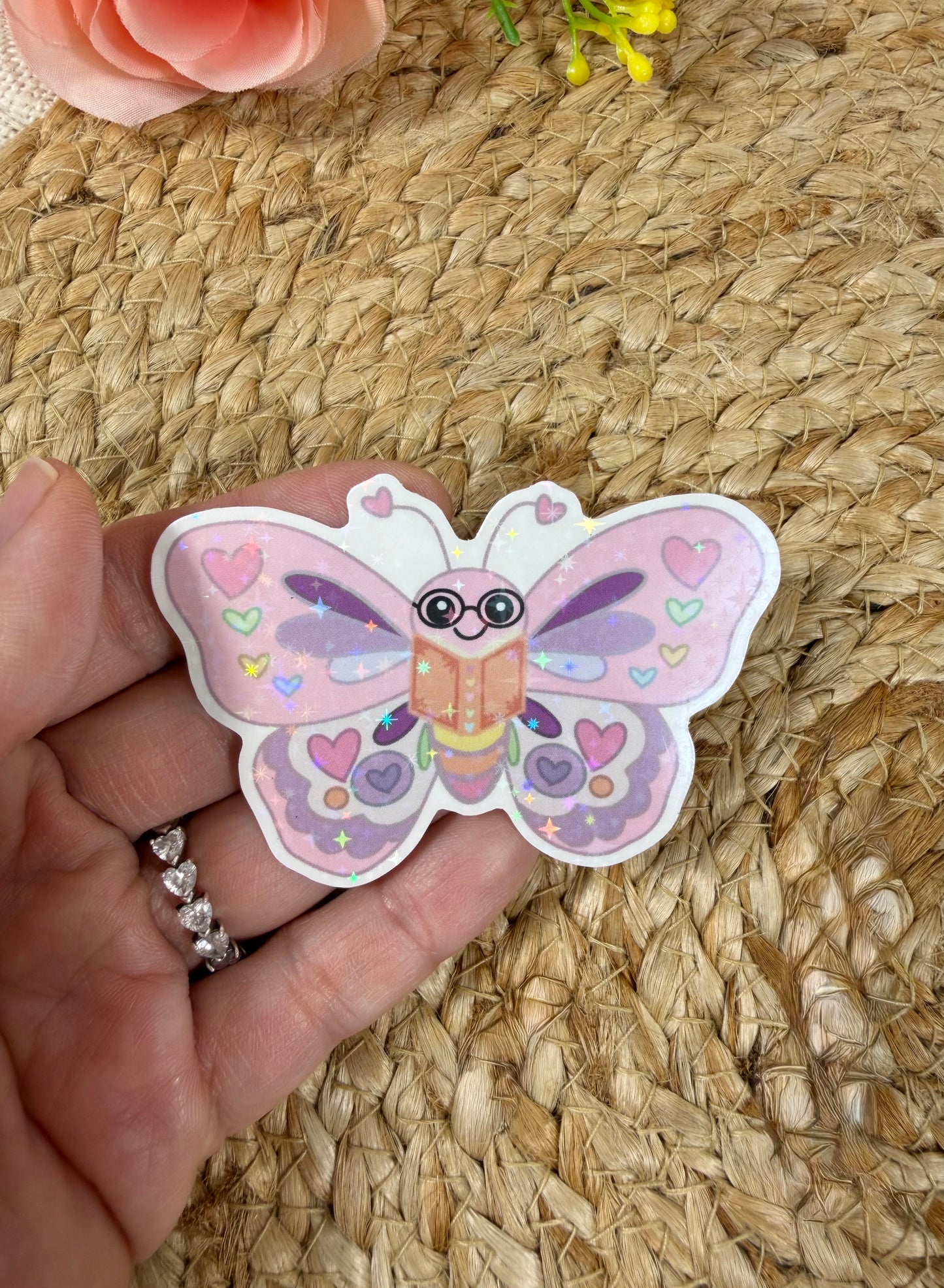 Close-up of the Butterfly Book Lover Vinyl Sticker in Vinyl Star Holographic finish held in hand.