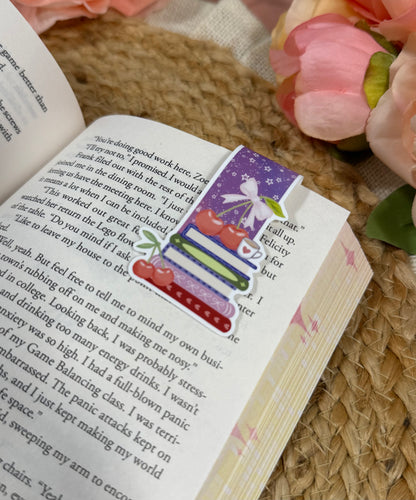Close-up of the Cherry Books Magnetic Bookmark clipped to a book page.