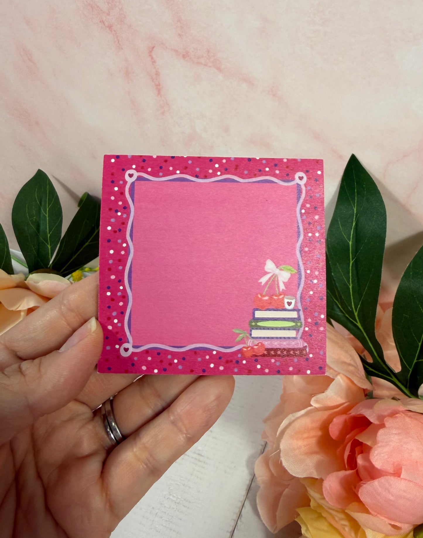 Cherry Books Sticky Notes held in hand to show their size and design.