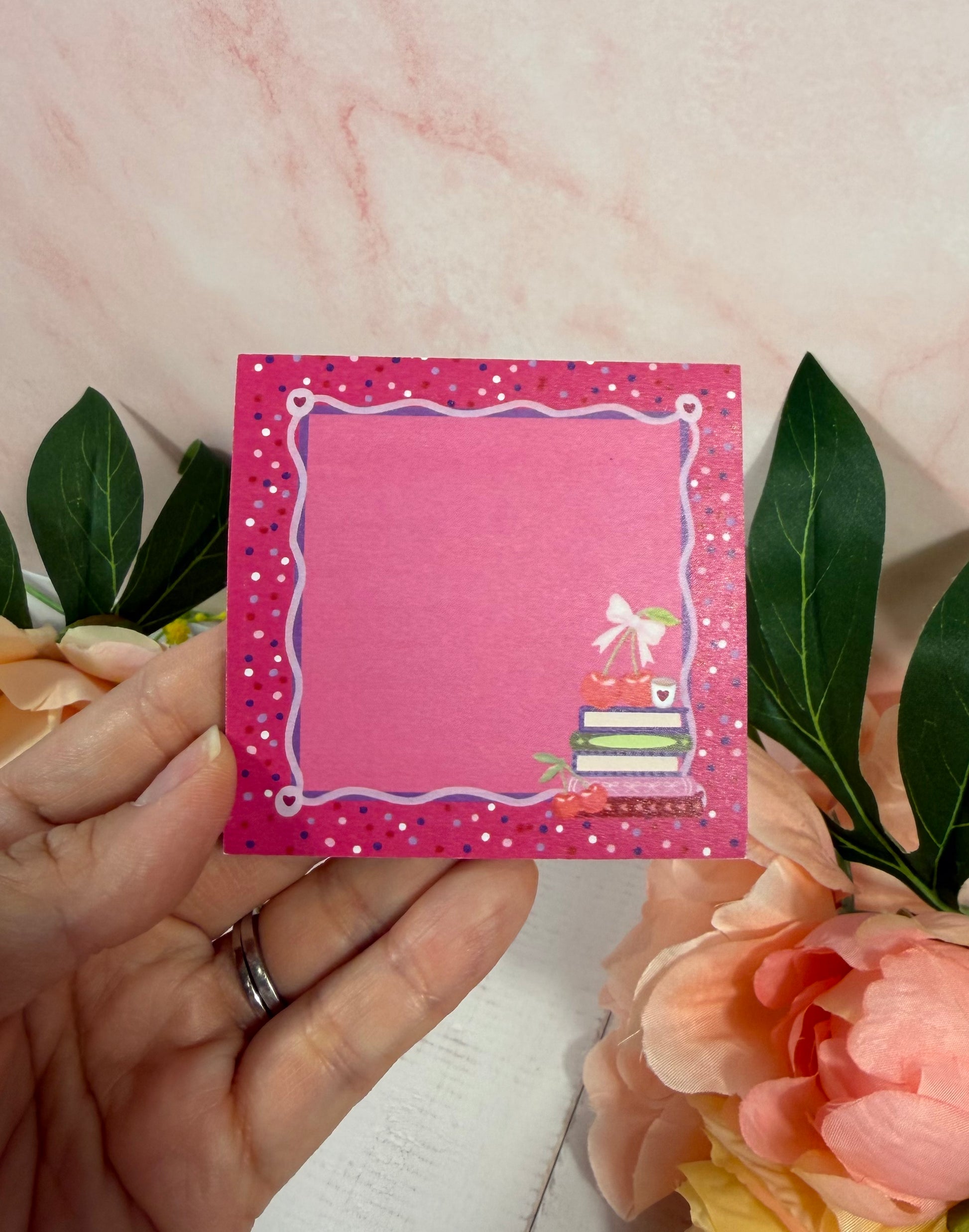 Cherry Books Sticky Notes held in hand to show their size and design.