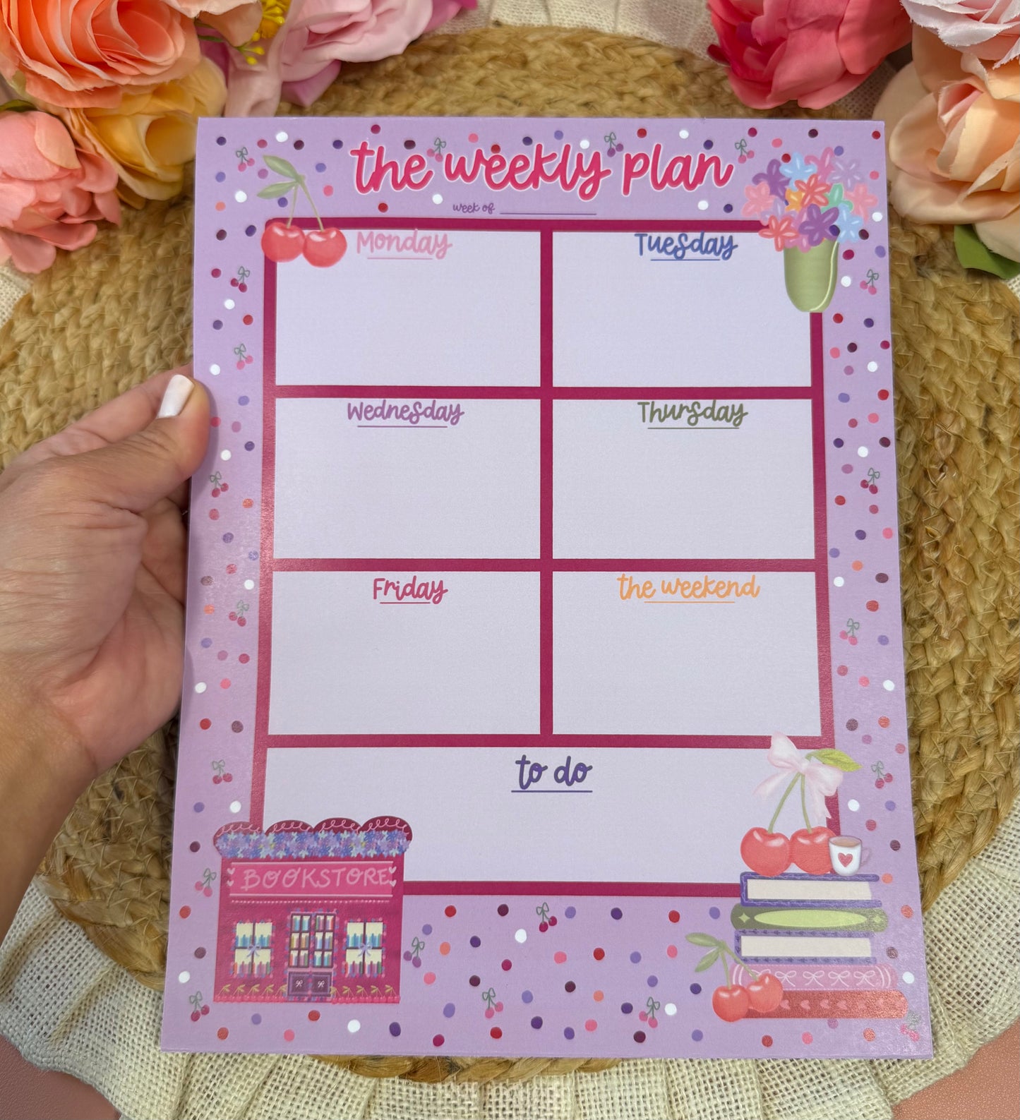Cherry Books Weekly Planner held in hand to show its size and design.