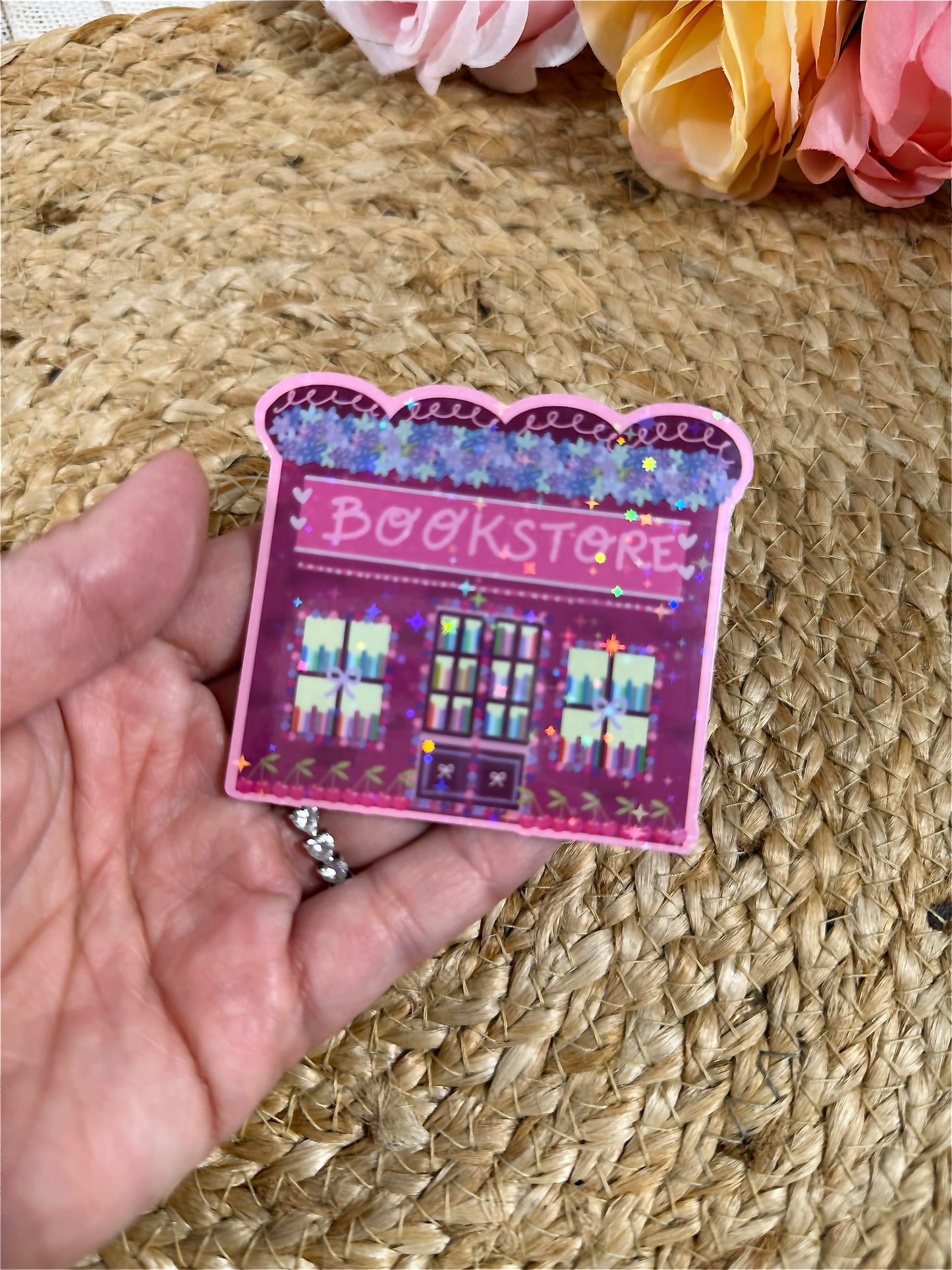Close-up of the Cherry Bookstore Vinyl Sticker in Vinyl Star Holographic finish held in hand.