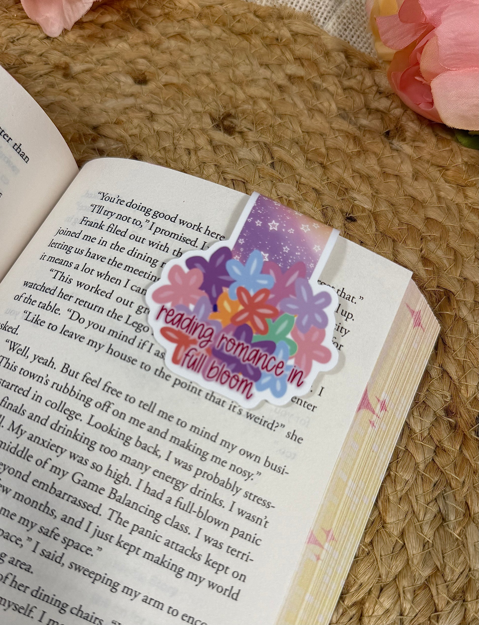 Close-up of the Flower Cup magnetic bookmark clipped to a book page, highlighting the artwork and design details.