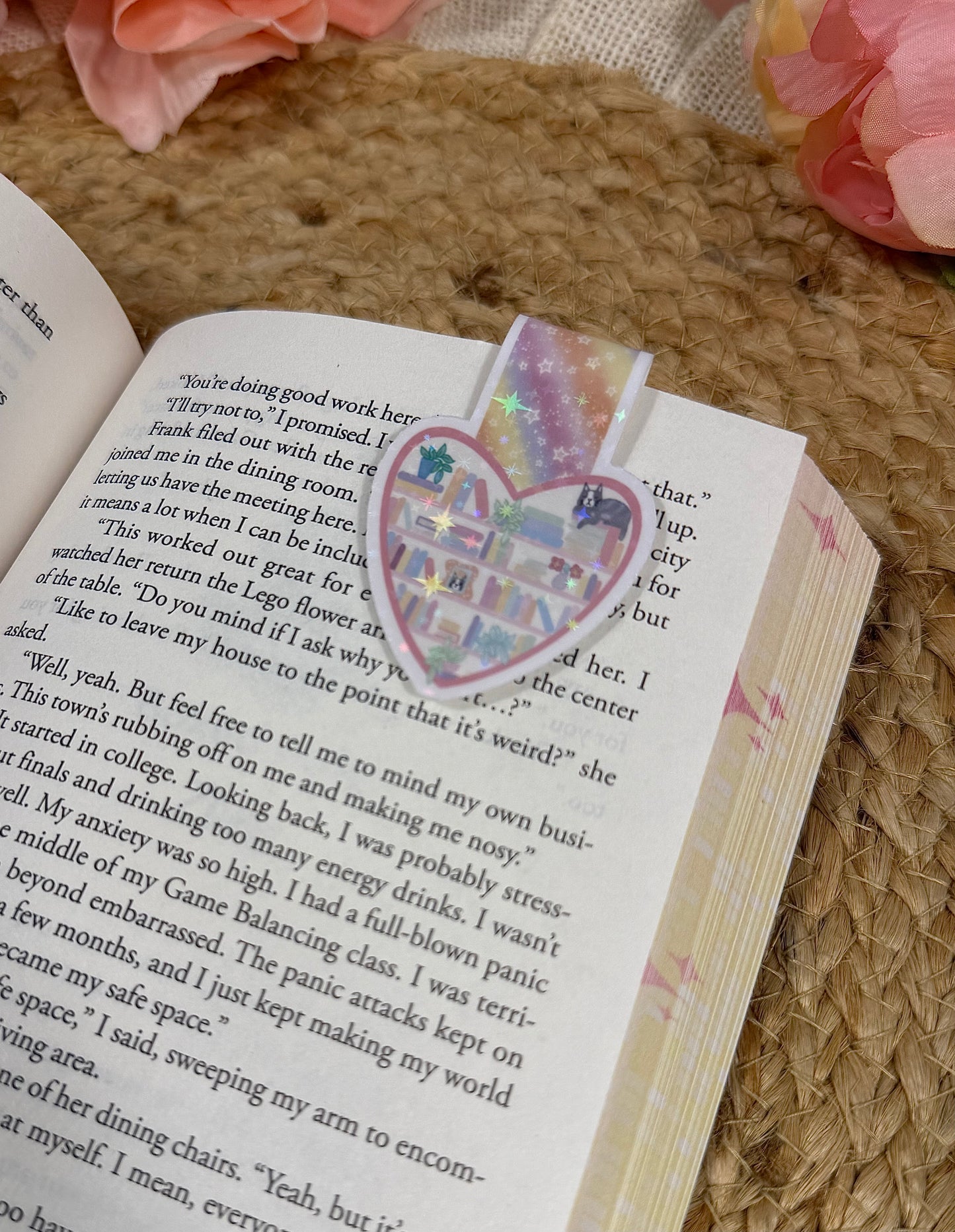 Close-up of the Kitty's Library magnetic bookmark clipped to a book page, highlighting the artwork and design details.