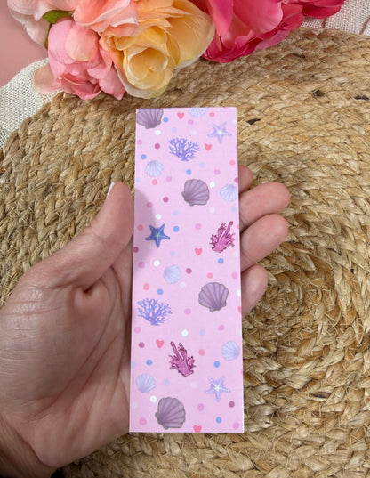 Pink Shores Bookmark held in hand.