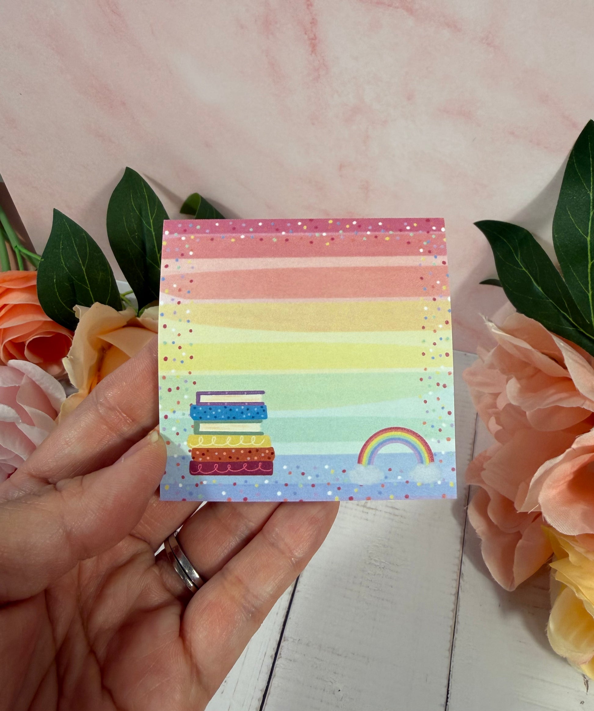 Rainbow Books Sticky Notes held in hand to show their size and design.
