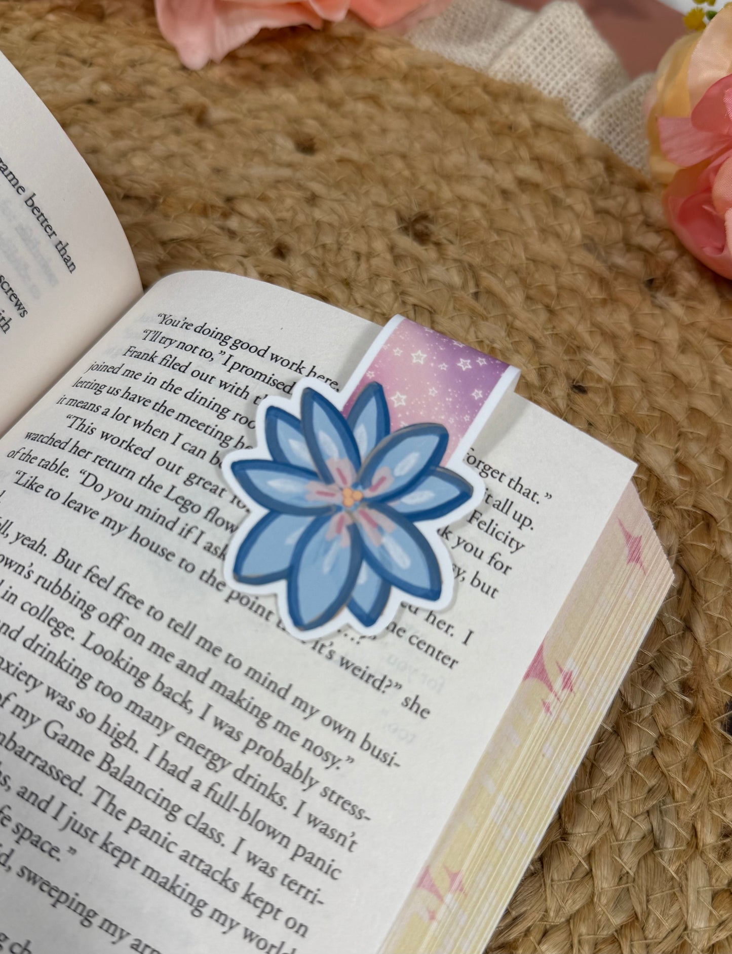 Close-up of the Rainbow Reading Romance magnetic bookmark clipped to a book page, highlighting the artwork and design details.