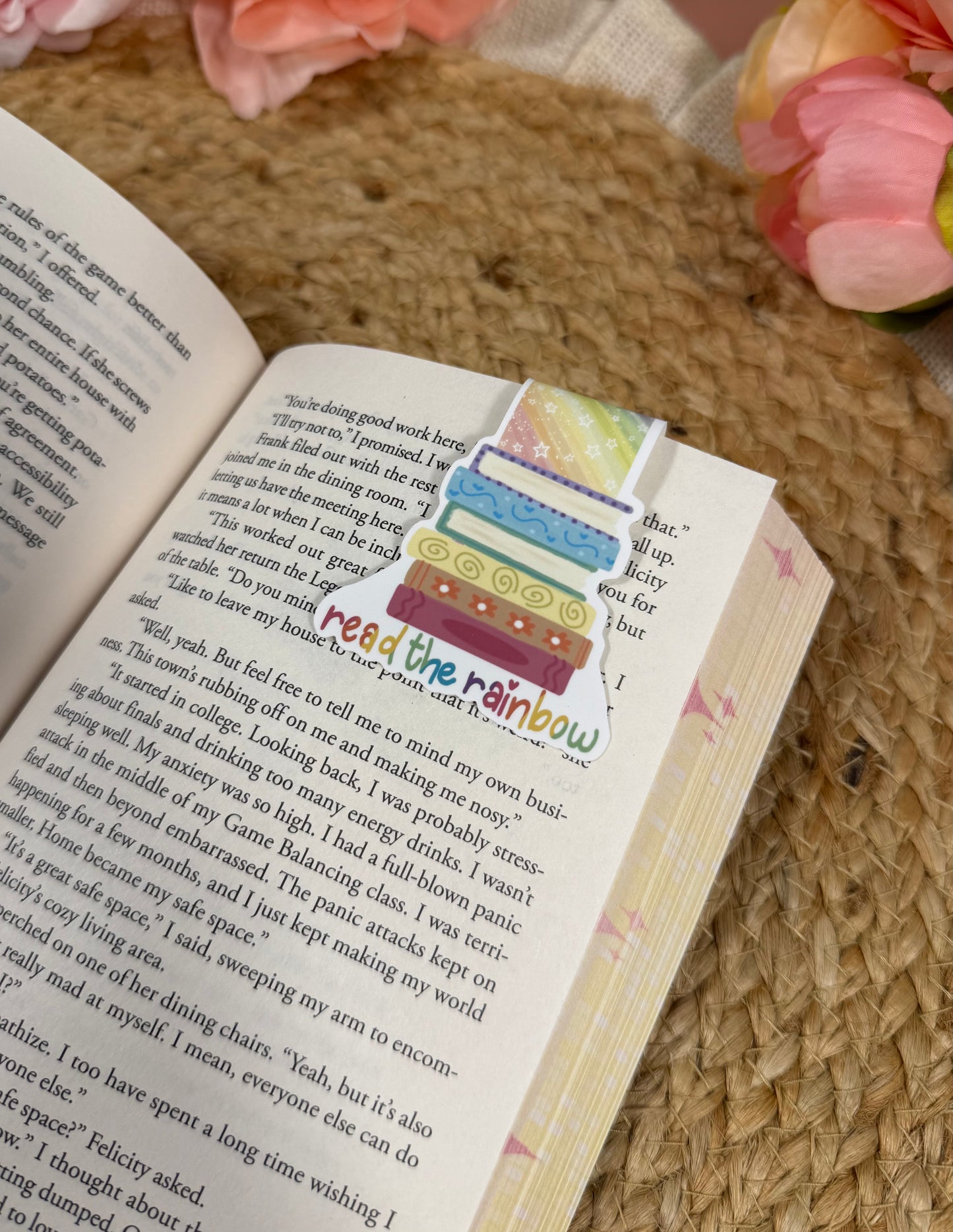 Close-up of the Read the Rainbow magnetic bookmark clipped to a book page, highlighting the artwork and design details.