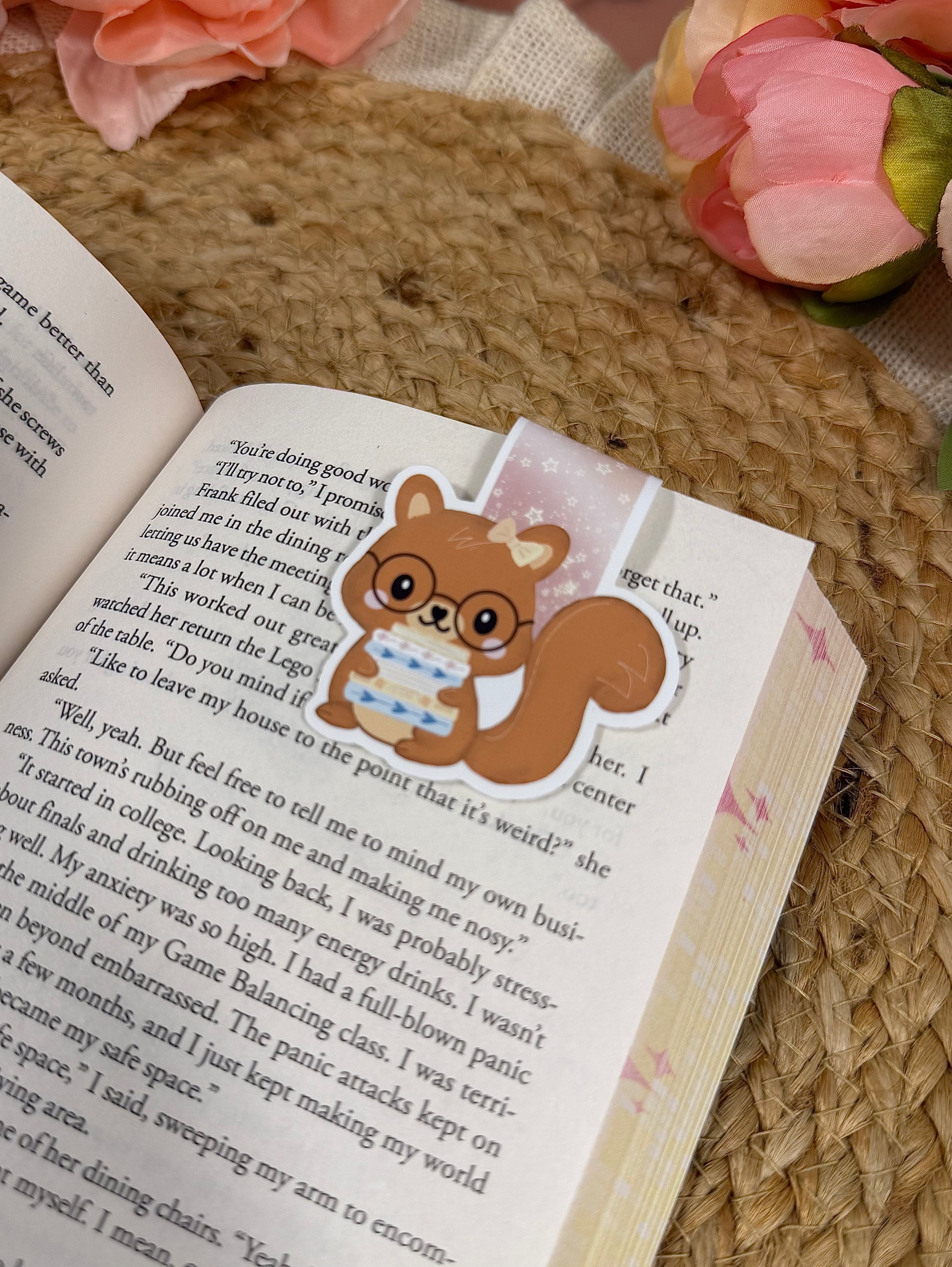 Close-up of the Storybook Squirrel magnetic bookmark clipped to a book page, highlighting the artwork and design details.