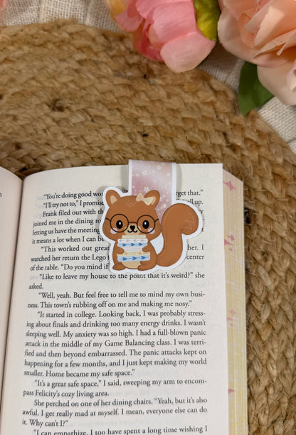 Storybook Squirrel magnetic bookmark clipped to a book page, showing how it marks your place while reading.