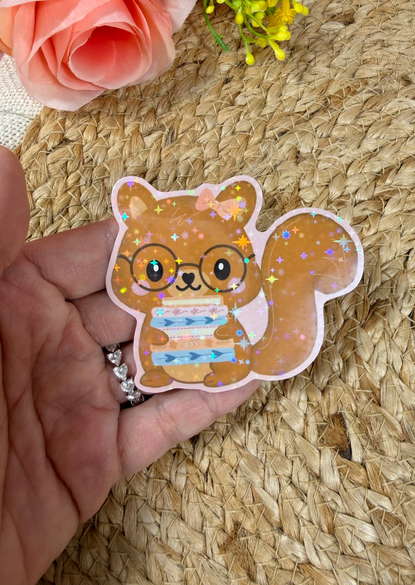 Close-up of the Storybook Squirrel Vinyl Sticker in Vinyl Star Holographic finish held in hand.
